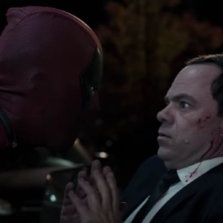The Recruiter is bleeding as Deadpool is looking at him right on his face.